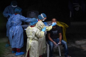 A foreign worker in Singapore has his sample taken for COVID-19 testing on April 27 (Photo: AFP/VNA)
