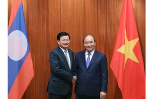 Prime Minister Nguyen Xuan Phuc meets with his Lao counterpart Thongloun Sisoulith during the Lao PM's visit to Vietnam on July 5. (Photo: VNA)