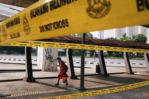 A woman wearing a protective mask walks on a street in Kuala Lumpur (Photo: Reuters)