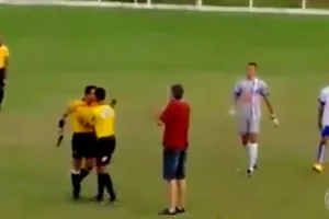 Trọng tài Murta cầm súng trong khi tranh luận với một thành viên đội Amantes da Bola.