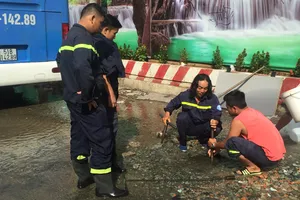 Lực lượng CS PCCC Q1 phối hợp nhân viên của Công ty cấp nước Bến Thành đang khắc phục sự cố. 