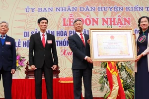 Bà Đặng Thị Bích Liên, Thứ trưởng Bộ Văn hóa Thể thao và Du lịch, trao Bằng công nhận “Di sản văn hóa phi vật thể quốc gia Hội Minh Thề” cho lãnh đạo huyện Kiến Thụy. Ảnh: Minh Thu-TTXVN