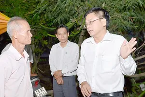Lãnh đạo huyện Bình Chánh đến nhà dân vận động việc giải phóng mặt bằng. Ảnh: VIỆT DŨNG