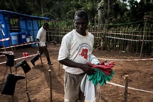 Nhân viên y tế khử trùng đồ đạc tại khu vực cách ly tại Muma, Cộng hòa Dân chủ Congo, sau khi phát hiện trường hợp nhiễm virus Ebola. Ảnh: TTXVN