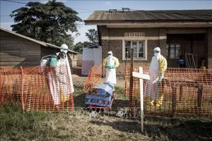 Nhân viên y tế phun thuốc khử trùng xung quanh quan tài một bệnh nhân tử vong do Ebola tại Beni, CHDC Congo. Ảnh: AFP/TTXVN