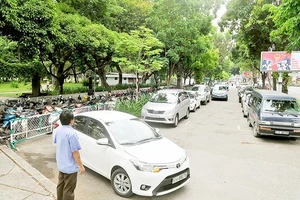 Ô tô đậu trên vỉa hè công viên Lê Văn Tám phía đường Hai Bà Trưng. Ảnh: THÀNH TRÍ