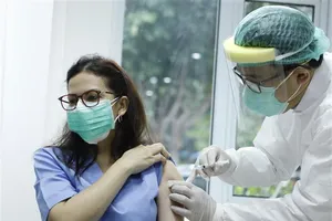 Nhân viên y tế tiêm phòng dịch COVID-19 cho người dân tại Jakarta, Indonesia. Ảnh: THX/TTXVN