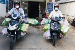  Anh Vương Hữu Dũng (phải) và anh em khu phố  chở hàng hóa cho bà con ở khu phong tỏa 
