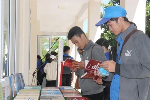 Tham khảo sách sau khi khai mạc triển lãm. Ảnh: TTXVN 