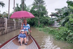 Người dân vùng thấp trũng tại huyện Quảng Điền, tỉnh Thừa Thiên Huế phải dùng thuyền nhỏ đi lại trên đường