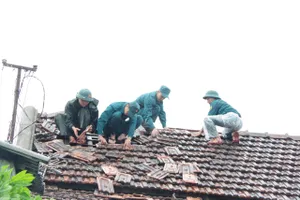 Lực lượng vũ trang TP Huế lợp lại mái nhà hư hỏng giúp người dân sau bão số 10