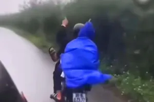 Nam sinh buông hai tay, lái xe bằng chân trên đường. Ảnh cắt từ video 