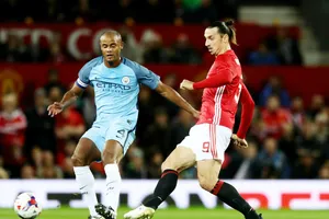 \Vincent Kompany (trái) tranh bóng với Zlatan Ibrahimovic ở trận derby Manchester. Ảnh: Getty Images 