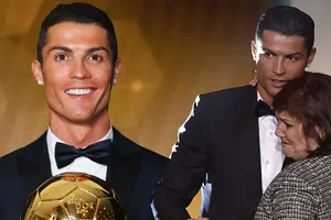 Ronaldo nâng cao Quả bóng Vàng thế giới trong vòng tay của mẹ. Ảnh: The Mirror