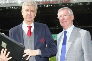 Sir Alex Ferguson (phải) trao quà lưu niệm cho HLV Arsene Wenger cuối tuần qua. Ảnh: Getty Images