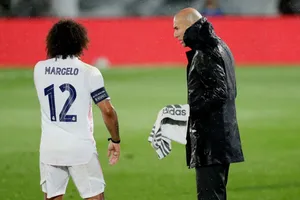 HLV Zinedine Zidane đội mưa sát cánh cùng các học trò. Ảnh: Getty Images