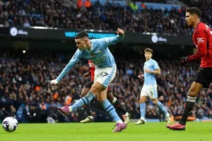 Chú thích: Phil Foden (trái, Manchester City) ghi bàn vào lưới Manchester United