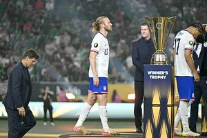 HLV Maurico Pochettino và các cầu thủ Mỹ lầm lũi bước qua chiếc Cúp Vàng.
