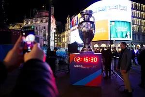 Người hâm mộ chụp ảnh bản sao cúp vô địch châu Âu và đồng hồ đếm ngược đến Euro 2028.