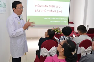 TS.BS Đinh Thế Trung trao đổi với đại biểu tại hội thảo Viêm gan siêu vi C- Sát thủ thầm lặng. Ảnh VIỆT DŨNG