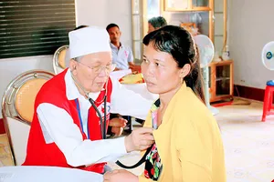 Bác sĩ CCB quân y khám bệnh cho đối tượng chính sách Ảnh: KHA ĐIỀN