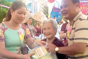 Vợ chồng anh Tú phát quà tặng người nghèo trong lễ Vu Lan tại chùa Phụng Ân Ảnh: HOÀI NAM