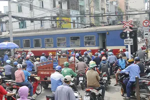 Phương tiện giao thông dừng lưu thông để xe lửa chạy qua Ảnh: thành trí