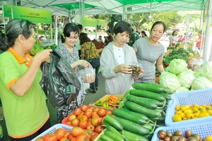 Người dân mua nông sản an toàn tại một chợ phiên. Ảnh: CAO THĂNG