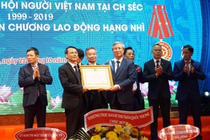 Thường trực Ban Bí thư Trần Quốc Vượng (phải) trao Huân chương Lao động hạng hai do Chủ tịch nước tặng Hội người Việt Nam tại Cộng hòa Czech. Ảnh: TTXVN