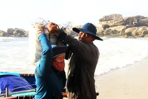 Người thân của ngư dân làng lưới thúng Trung Lương mang cá đi bán tại các phiên chợ gần làng