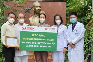 Ban Giám đốc BV Phạm Ngọc Thạch nhận bảng tượng trưng hỗ trợ từ đại diện Báo SGGP và Công ty Phúc Khang