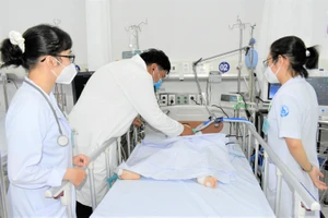 Bác sĩ Đinh Tấn Phương, Khoa Cấp cứu Bệnh viện Nhi đồng 1, TPHCM thăm khám cho bệnh nhi trưa 10-6