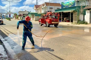 Thành viên Đội PCCC và CHCN tự quản thị trấn Lạc Dương xịt rửa đường ở những khu vực vừa xảy ra sạt lở, bùn đất tràn xuống đường giao thông