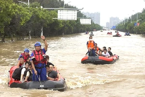 Lực lượng cứu hộ đưa người dân ở TP Trác Châu, tỉnh Hà Bắc, Trung Quốc đi sơ tán. Ảnh: AP