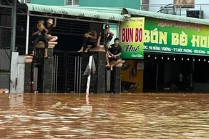 Cơn mưa lớn kéo dài tối ngày 27-7 làm nước dâng khiến người dân leo lên cao chờ lực lượng chức năng đến hỗ trợ