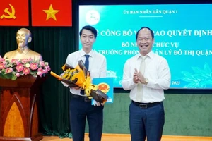 Chủ tịch UBND quận 1 Lê Đức Thanh trao quyết định bổ nhiệm chức danh Phó Trưởng Phòng Quản lý đô thị quận cho ông Dương Thanh Bình - người trúng tuyển kỳ thi chức danh lãnh đạo, quản lý cấp phòng do UBND quận 1 tổ chức