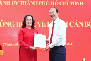 Phó Bí thư Thường trực Thành ủy TPHCM Nguyễn Hồ Hải trao quyết định đến đồng chí Huỳnh Thị Lan Hương. Ảnh: VIỆT DŨNG