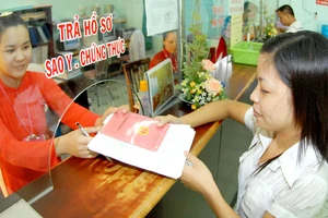 Nhân viên UBND phường Hiệp Bình Chánh (mặc áo dài) giải quyết hồ sơ cho người dân. Ảnh: KIM NGÂN