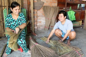 Chị Lam đang hướng dẫn cho một người đồng cảnh ngộ cách làm chổi 