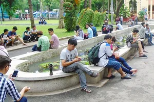 Hình ảnh các nhóm bạn trẻ cùng ngồi bên nhau nhưng không ai  nói chuyện với ai, chỉ “ôm” ĐTDĐ đã trở nên quen thuộc. Ảnh: ĐOÀN HIỆP