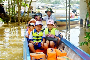 Học sinh vùng lũ đầu nguồn An Phú (An Giang) được đưa rước đến trường miễn phí