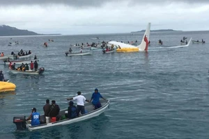 Lực lượng cứu hộ đang đưa những người gặp nạn trên máy bay ra ngoài. Ảnh: Reuters