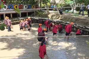 Khách du lịch trải nghiệm việc lội bùn bắt cá