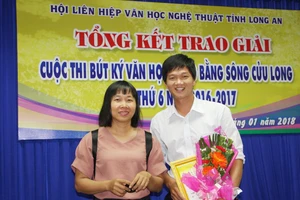 Tác giả trẻ Trương Chí Hùng nhận giải nhất cuộc thi Bút ký ĐBSCL năm 2018, bên cạnh là nhà văn Nguyễn Ngọc Tư. Ảnh: QUỐC TUẤN