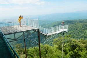 Khách du lịch ra lan can không an toàn để chụp hình tại trạm dừng chân trên đèo Đại Ninh