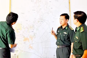 Đại tá Phan Minh Huyền (giữa), Bộ đội Biên phòng tỉnh An Giang, trao đổi về công tác phòng chống tội phạm trên bản đồ biên giới