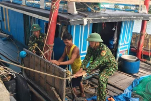 Bộ đội Biên phòng Hà Tĩnh giúp ngư dân chằng chống tàu để tránh bão. Ảnh: DƯƠNG QUANG