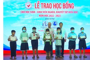 Các em học sinh, sinh viên có hoàn cảnh khó khăn nhận học bổng. Ảnh: VGP