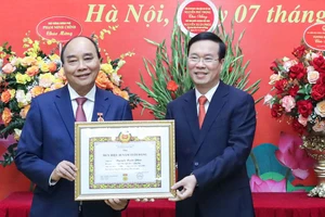 Thường trực Ban Bí thư Võ Văn Thưởng trao Huy hiệu 40 năm tuổi Đảng tặng Chủ tịch nước Nguyễn Xuân Phúc. Ảnh: QUỐC HÙNG