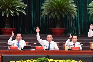 Các đồng chí lãnh đạo TPHCM biểu quyết thông qua nghị quyết hội nghị. Ảnh: VIỆT DŨNG